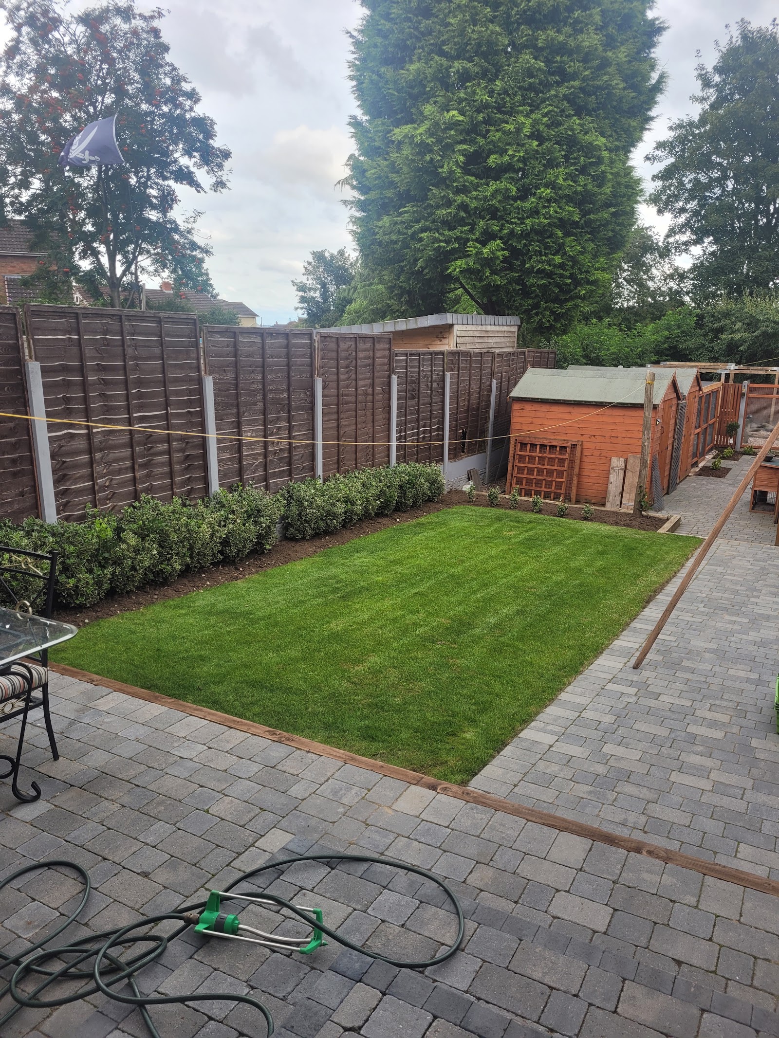 New lawn and block-paved border laid across a rear garden